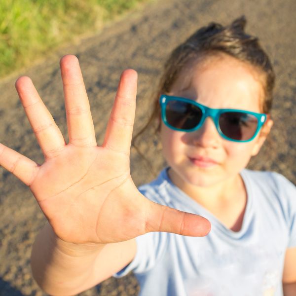 Child with the number five displayed on their hands