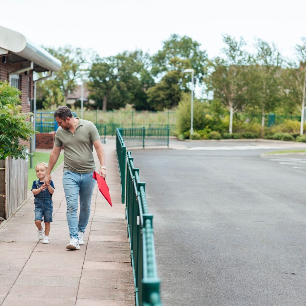 Father walking daughter into preschool