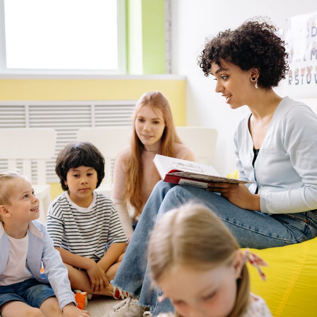 Preschool teacher reading to children in a circle